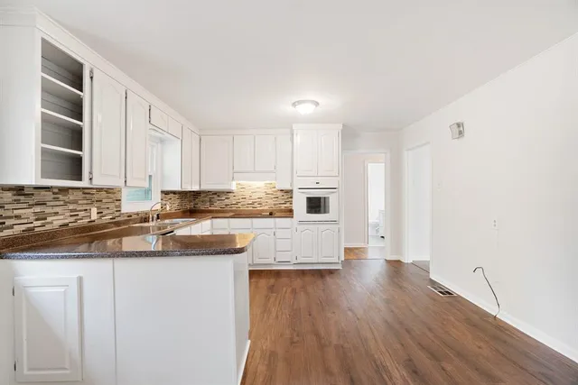 a kitchen with kitchen island granite countertop a sink cabinets and stainless steel appliances