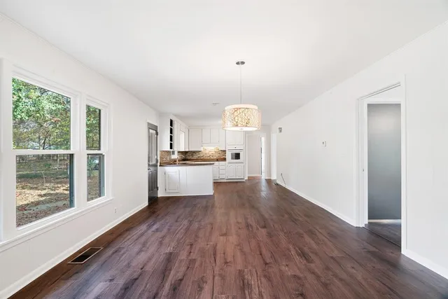 a view of a kitchen with wooden floor and electronic appliances