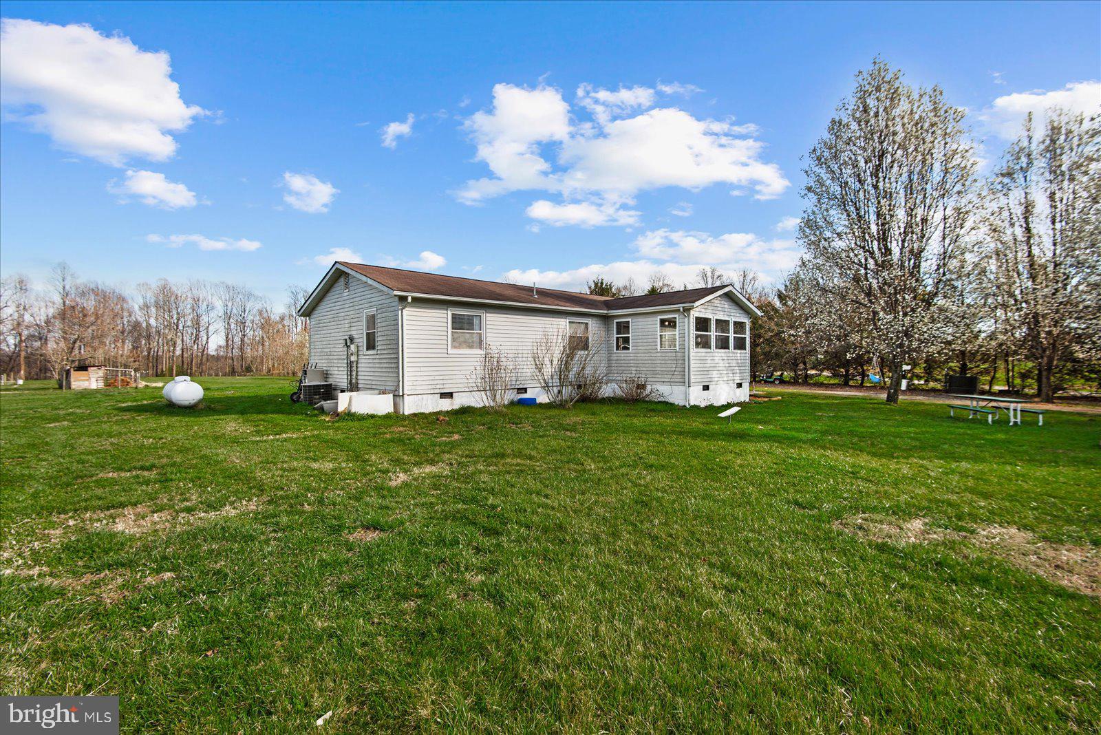 23165 Fork Bridge Road Milford, VA 22514 - Photo 29 of 51 a view of a white house in front of a big yard with plants and large trees