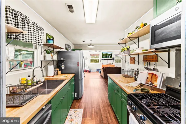 a kitchen with stainless steel appliances granite countertop a stove and cabinets