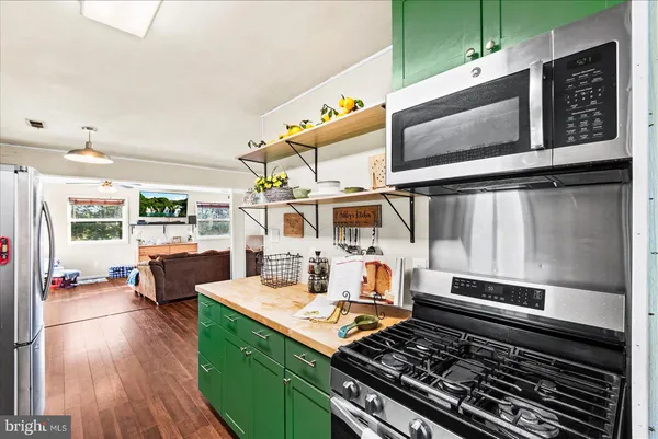 a open kitchen with stainless steel appliances kitchen island granite countertop a stove and a sink