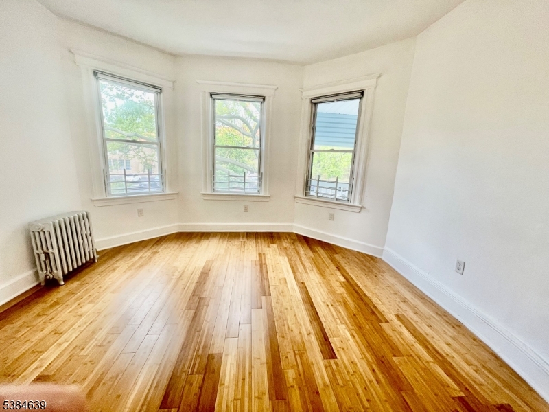 169 Hillside Avenue, Unit 2 Glen Ridge, NJ 07028 - Photo 3 of 10 an empty room with wooden floor and windows