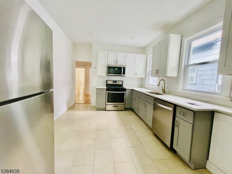 169 Hillside Avenue, Unit 2 Glen Ridge, NJ 07028 - Photo 6 of 10 a kitchen with stainless steel appliances a refrigerator sink and microwave