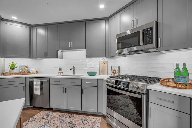 a kitchen with stainless steel appliances granite countertop a sink stove and microwave