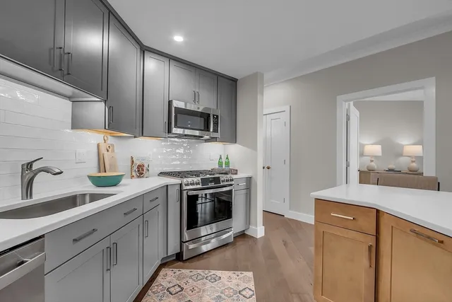 a kitchen with stainless steel appliances granite countertop a sink stove and refrigerator
