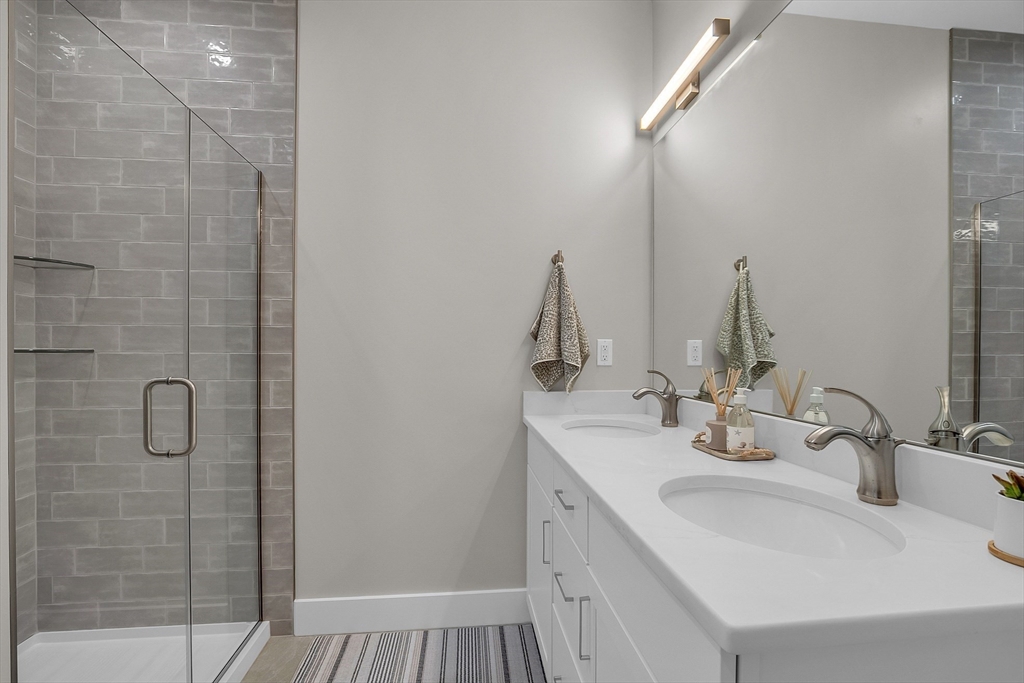 55 Pointe Place, Unit 108 Dover, NH 03820 - Photo 27 of 33 a bathroom with a double vanity sink and a mirror