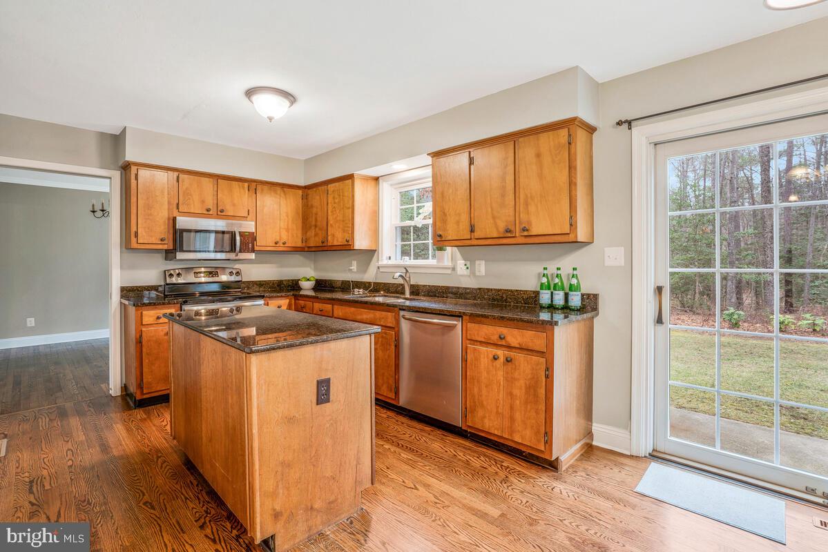 44576 Cedar Court California, MD 20619 - Photo 14 of 45 a kitchen with stainless steel appliances granite countertop a stove a sink and a refrigerator