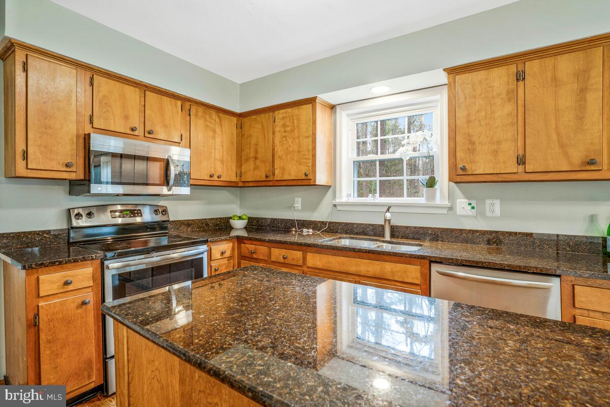 44576 Cedar Court California, MD 20619 - Photo 17 of 45 a kitchen with stainless steel appliances granite countertop a stove a sink and a microwave