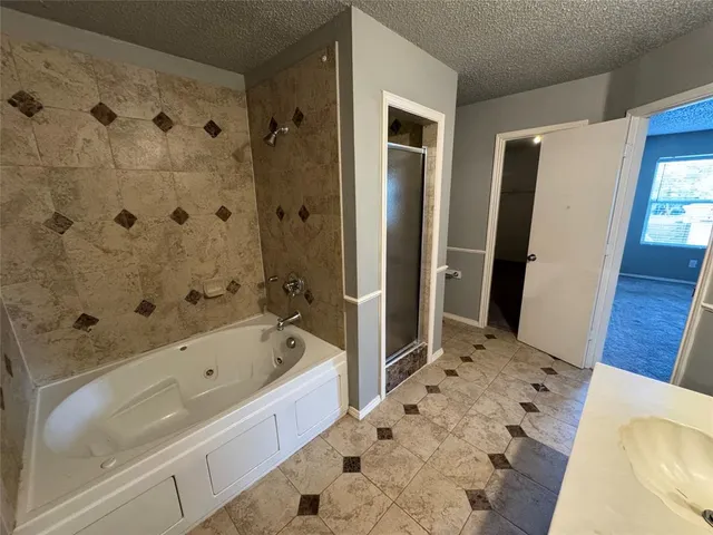 a bathroom with a tub sink and mirror