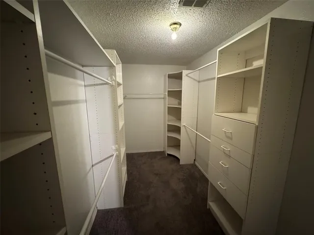 a view of walk in closet with empty racks