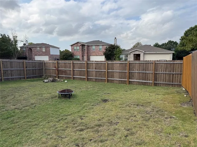 a view of a backyard with a fence and plants