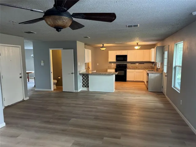 a view of a kitchen with a sink wooden floor and a window