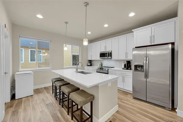 a kitchen with granite countertop a sink a counter top space stainless steel appliances and cabinets