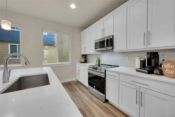 a large kitchen with kitchen island a large island a sink a stove and a center island