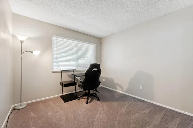a view of a workspace with furniture and a window