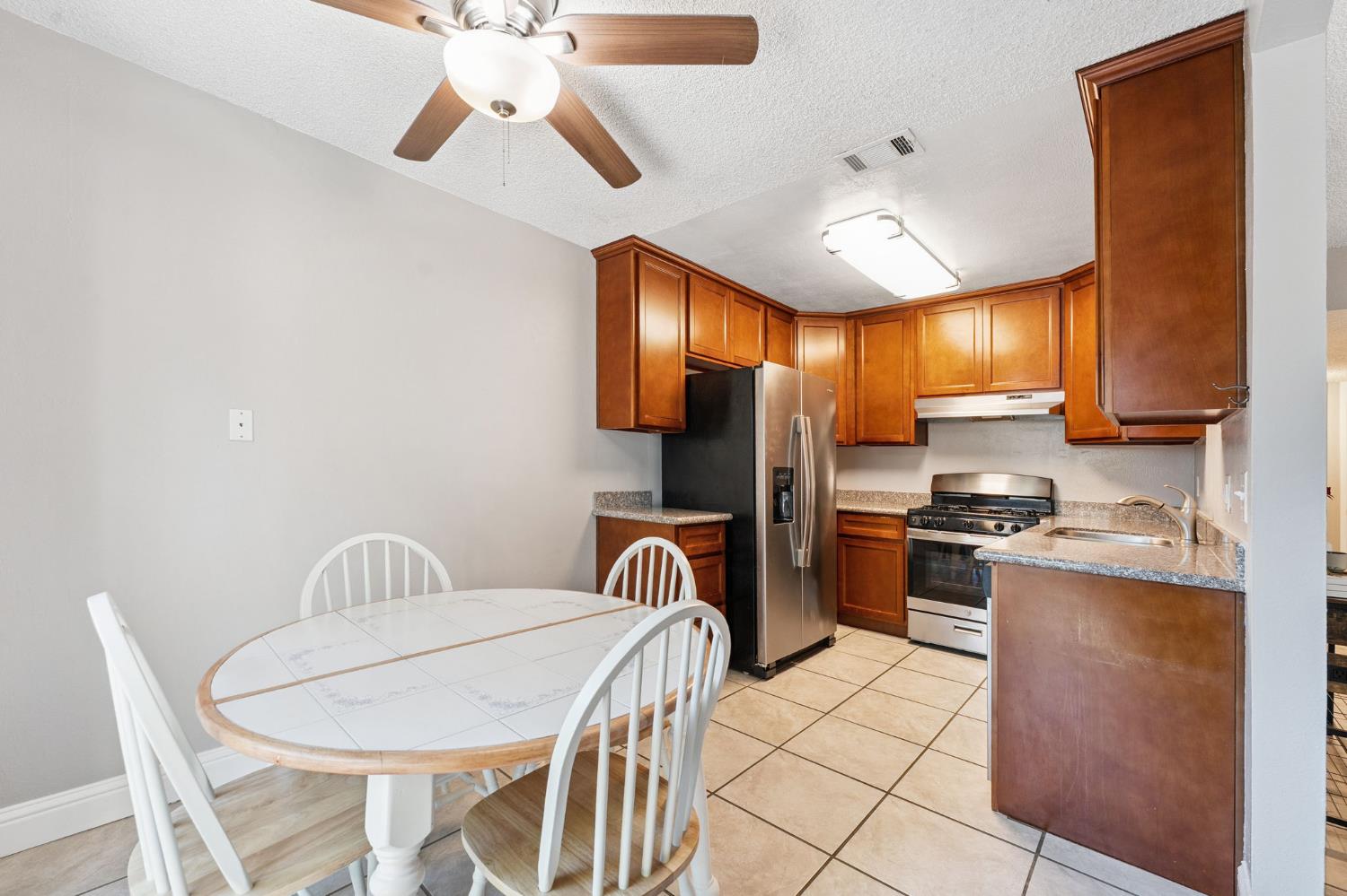 56 West Elliot Street, Unit 61 Woodland, CA 95695 - Photo 6 of 17 a kitchen with stainless steel appliances granite countertop a sink a stove and a refrigerator