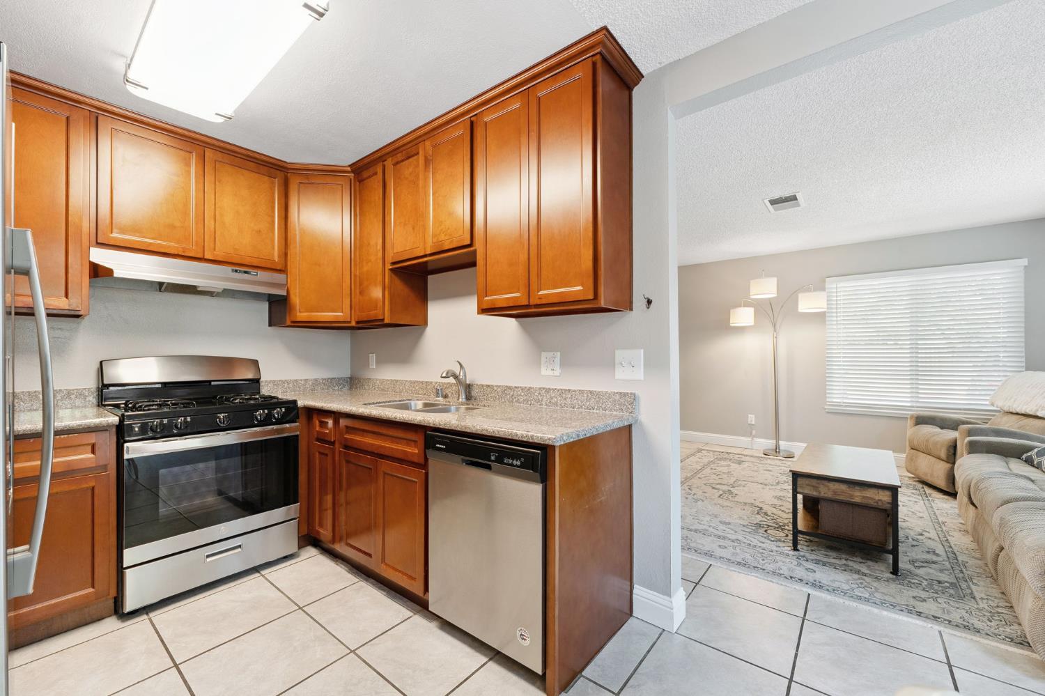 56 West Elliot Street, Unit 61 Woodland, CA 95695 - Photo 7 of 17 a kitchen with stainless steel appliances granite countertop a stove a sink and a microwave