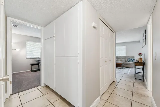 a view of a hallway to closet and a living room
