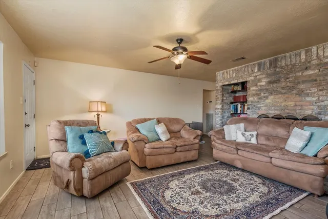 a living room with furniture and a flat screen tv with wooden floor