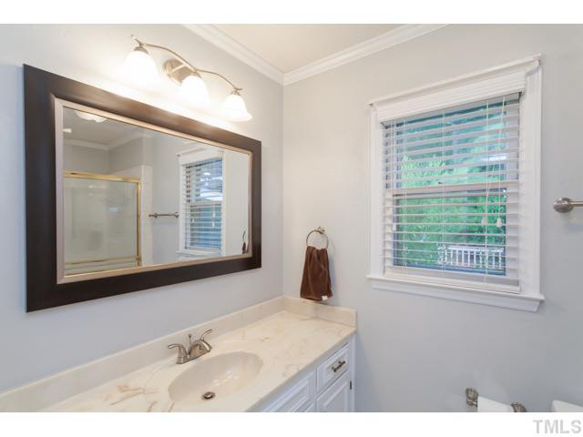 7312 Wilderness Road Raleigh, NC 27613 - Photo 14 of 23 a bathroom with a sink vanity and a mirror