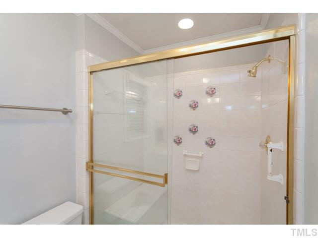 7312 Wilderness Road Raleigh, NC 27613 - Photo 15 of 23 a bathroom with a shower and a glass door