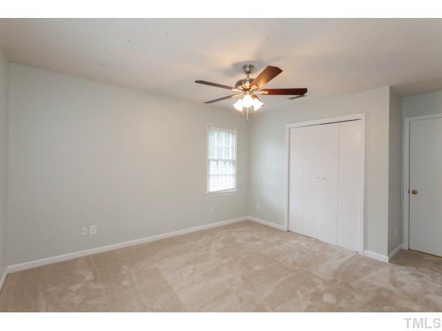 7312 Wilderness Road Raleigh, NC 27613 - Photo 18 of 23 a view of an empty room with a chandelier fan