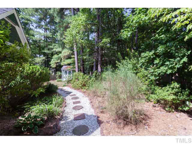 7312 Wilderness Road Raleigh, NC 27613 - Photo 22 of 23 a view of a yard with plants and large trees