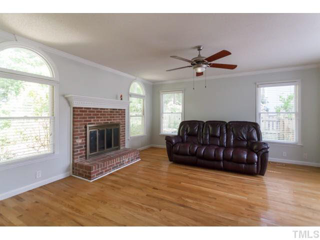 7312 Wilderness Road Raleigh, NC 27613 - Photo 4 of 23 a living room with furniture a fireplace and a large window