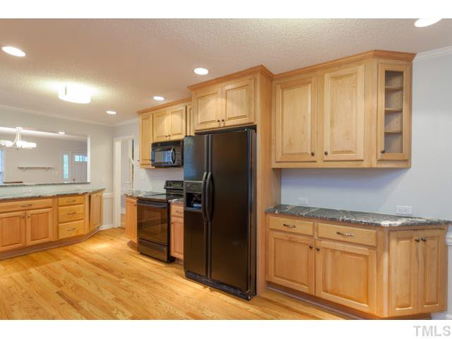 7312 Wilderness Road Raleigh, NC 27613 - Photo 6 of 23 a kitchen with stainless steel appliances granite countertop a refrigerator a stove top oven and a sink