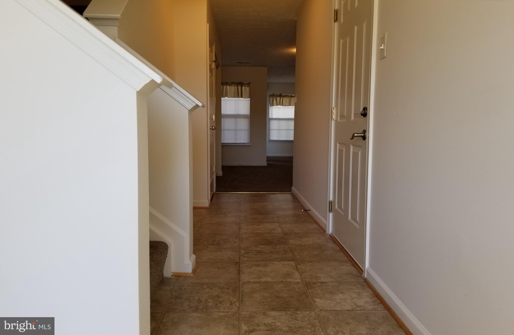 9736 Selfridge Road Baltimore, MD 21220 - Photo 30 of 35 a view of a hallway with wooden floor and staircase