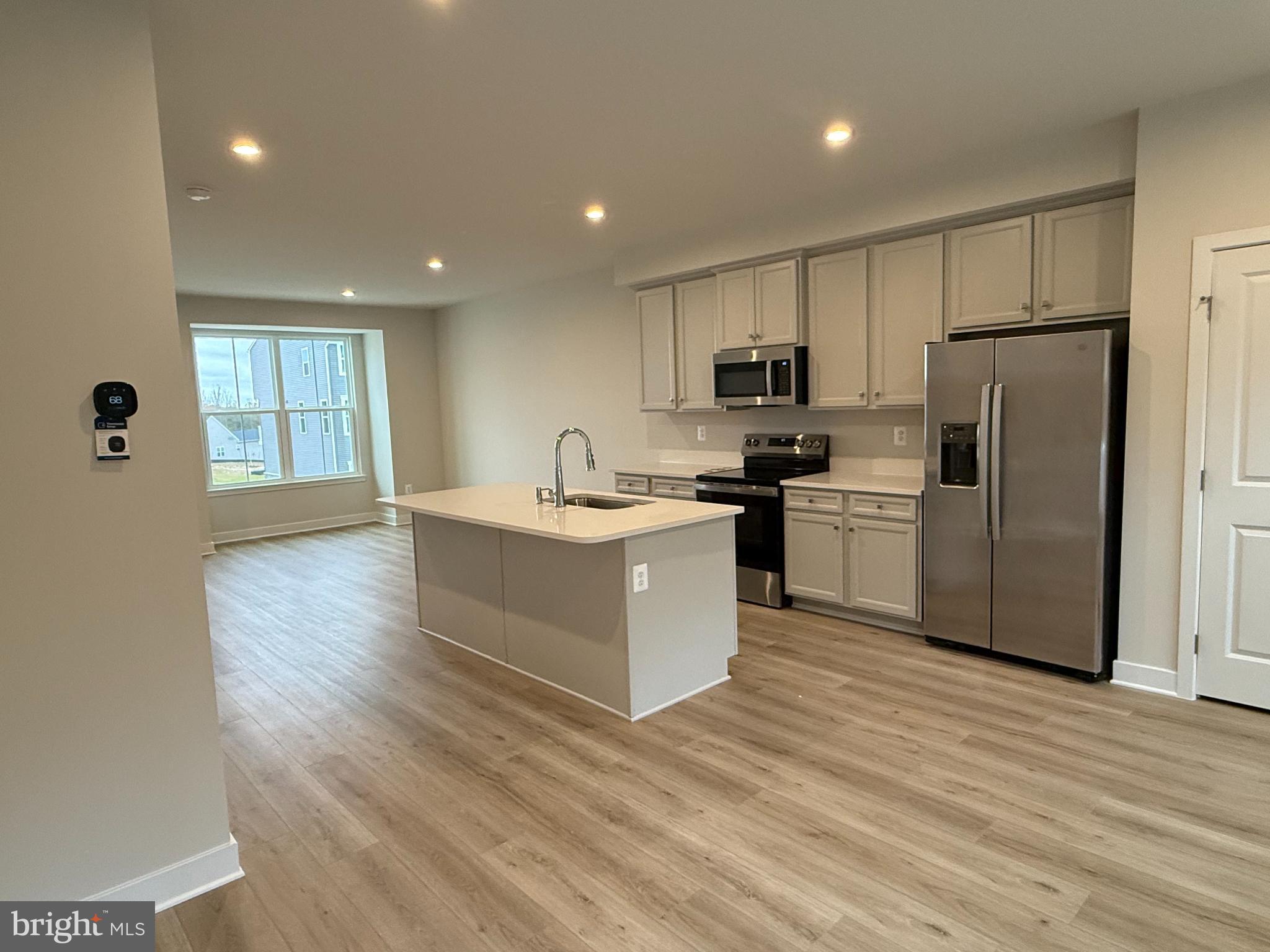 6932 Braxton Springs Way Spotsylvania, VA 22553 - Photo 30 of 33 a kitchen with a refrigerator a sink and cabinets