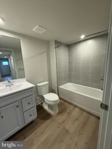 a bathroom with a bathtub shower sink mirror and toilet