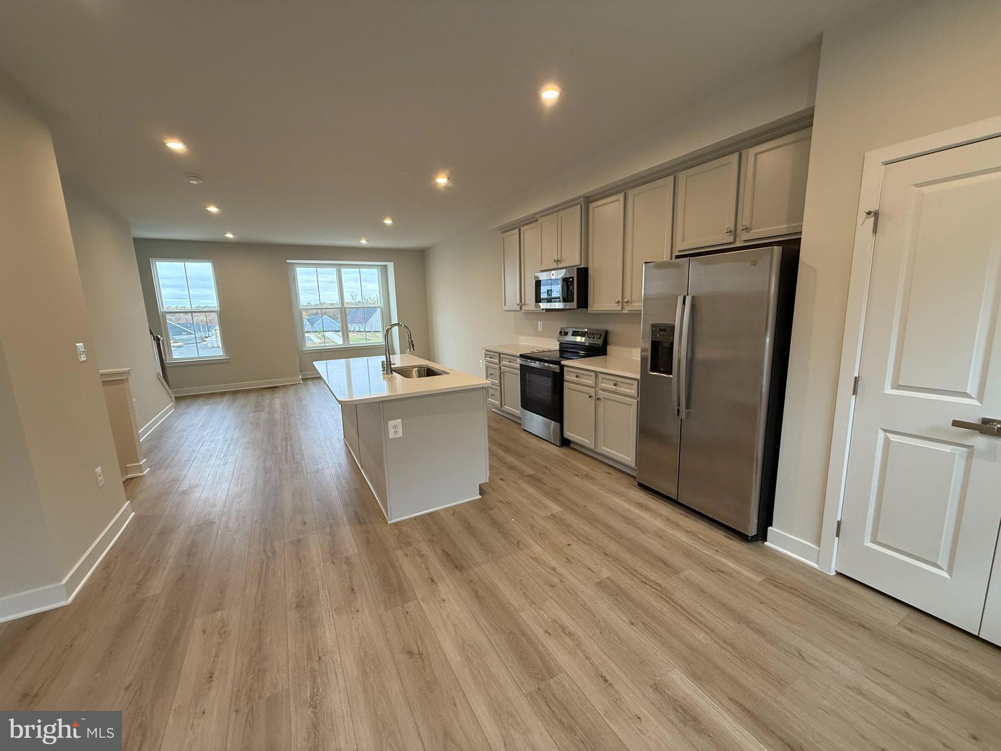 6932 Braxton Springs Way Spotsylvania, VA 22553 - Photo 7 of 33 a kitchen with stainless steel appliances a refrigerator and wooden floor