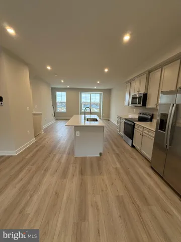 a kitchen with stainless steel appliances a refrigerator sink stove and microwave