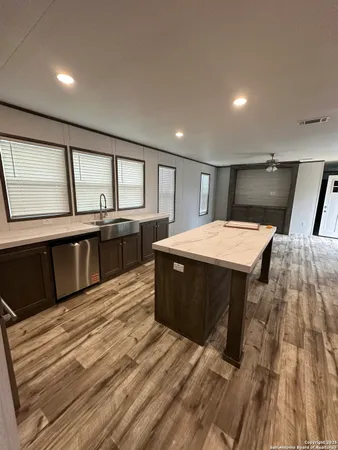 a large kitchen with a stove and wooden floor