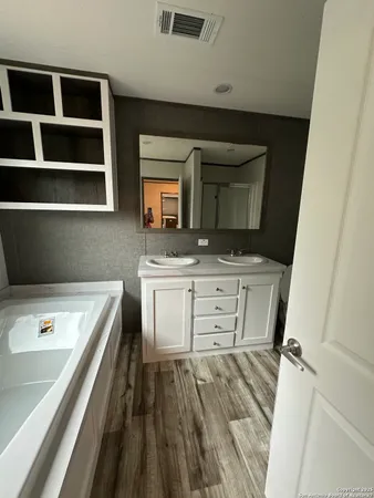 a bathroom with a sink a large mirror and a bathtub