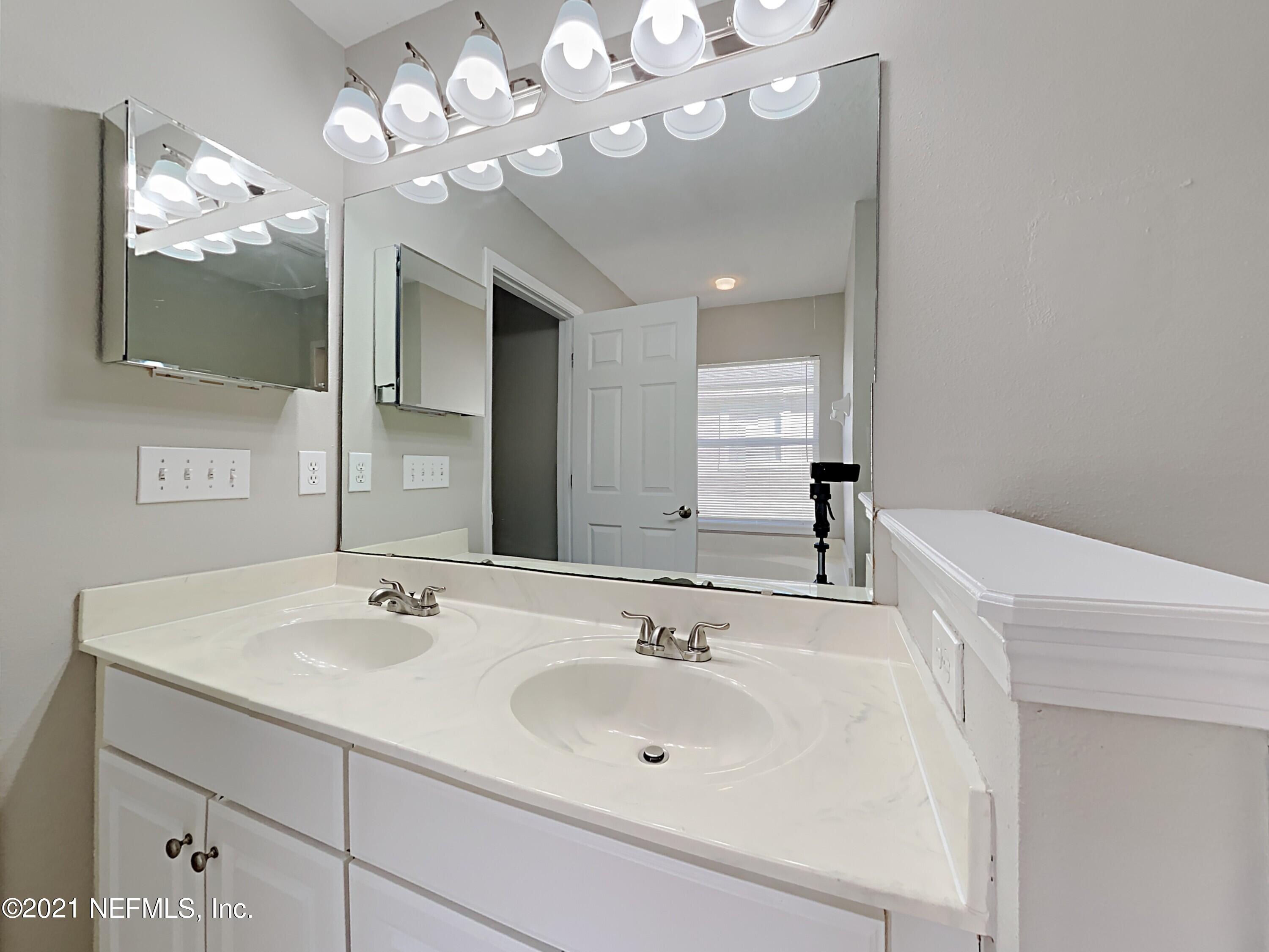 600 Birchbark Trail St. Augustine, FL 32092 - Photo 8 of 16 a bathroom with a sink a large mirror and vanity