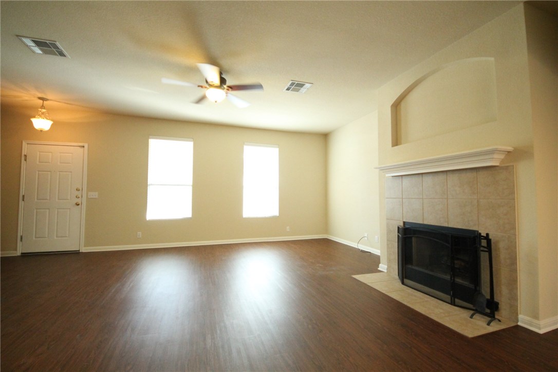 9600 Magna Carta Loop, Unit 177 Austin, TX 78754 - Photo 3 of 25 an empty room with wooden floor a fireplace and windows