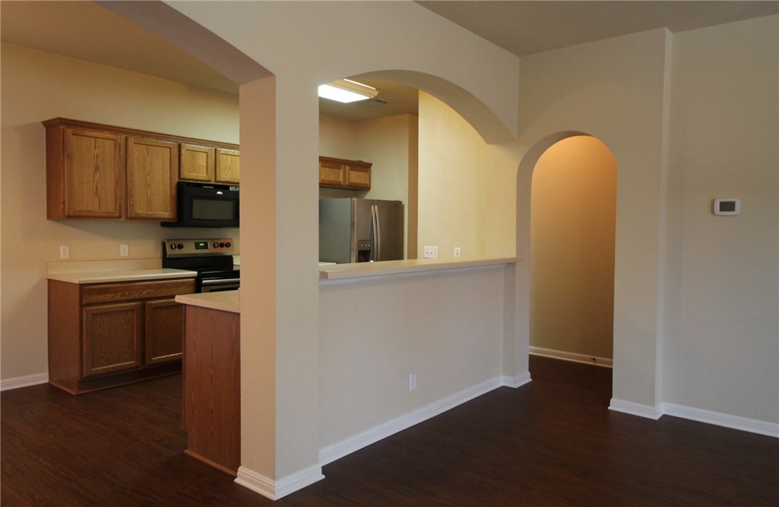 9600 Magna Carta Loop, Unit 177 Austin, TX 78754 - Photo 5 of 25 a kitchen with stainless steel appliances granite countertop a stove a sink and a refrigerator