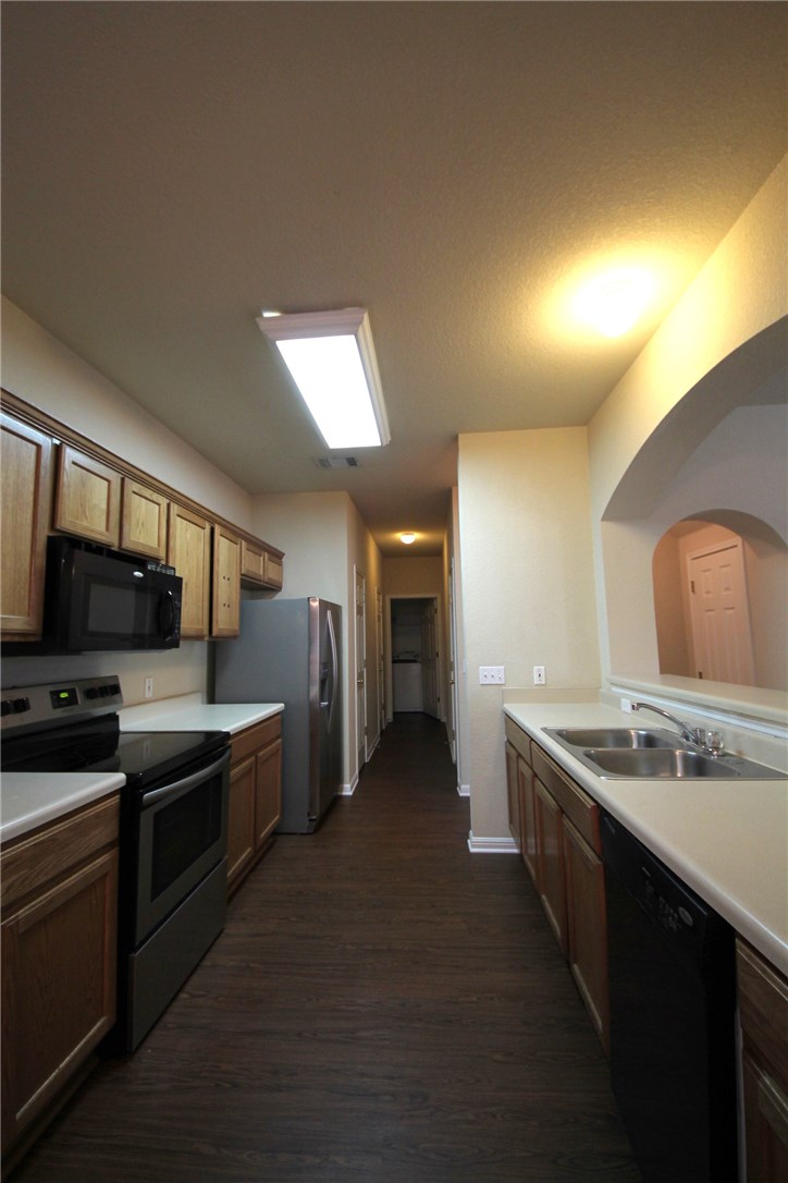 9600 Magna Carta Loop, Unit 177 Austin, TX 78754 - Photo 7 of 25 a kitchen with stainless steel appliances granite countertop a sink and stove top oven