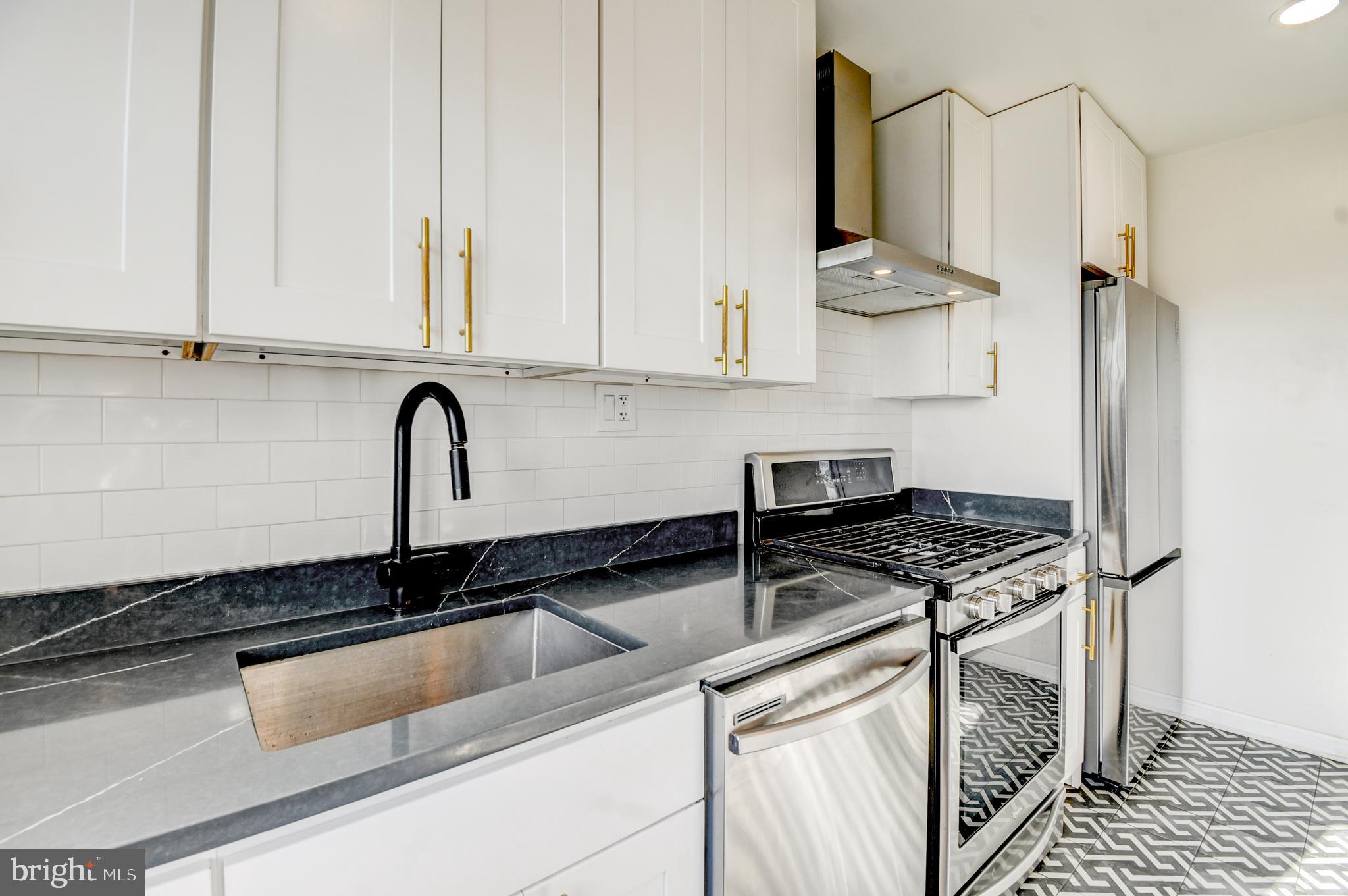 1371 Adams Street Northeast Washington, DC 20018 - Photo 11 of 34 a kitchen with stainless steel appliances a sink stove and cabinets