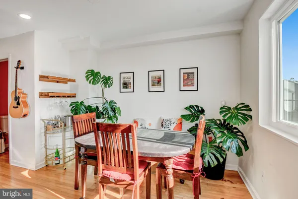 a dining room with furniture potted plants and wooden floor