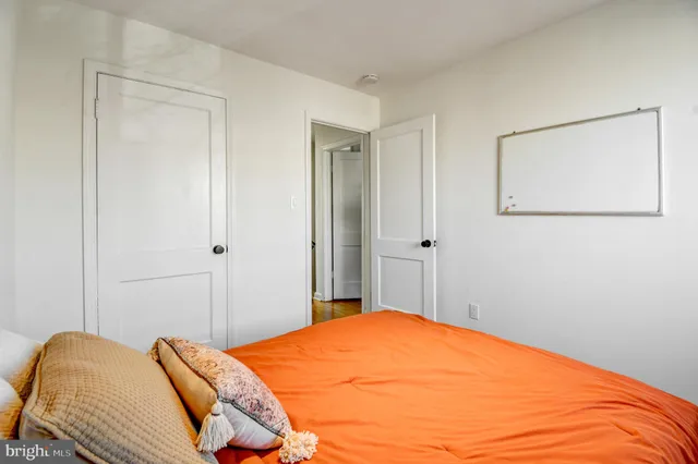 a bedroom with a bed and a painting on the wall