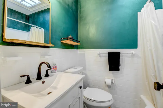 a bathroom with a toilet sink and mirror