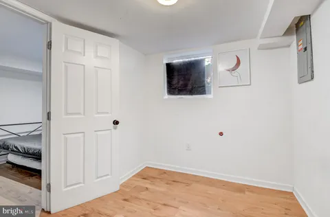 a view of a livingroom with wooden floor and bathroom