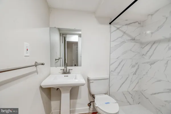 a bathroom with a toilet sink and mirror