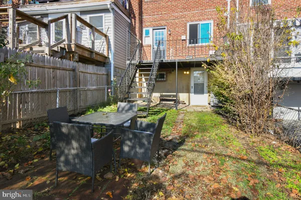 a view of a patio with table and chairs with wooden fence