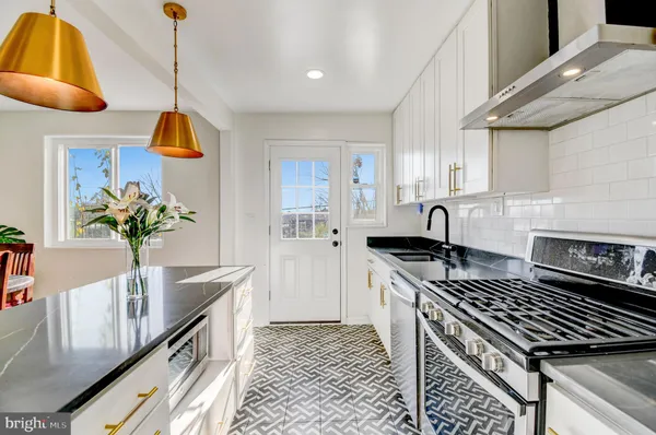 a kitchen with stainless steel appliances granite countertop a stove a sink and a refrigerator