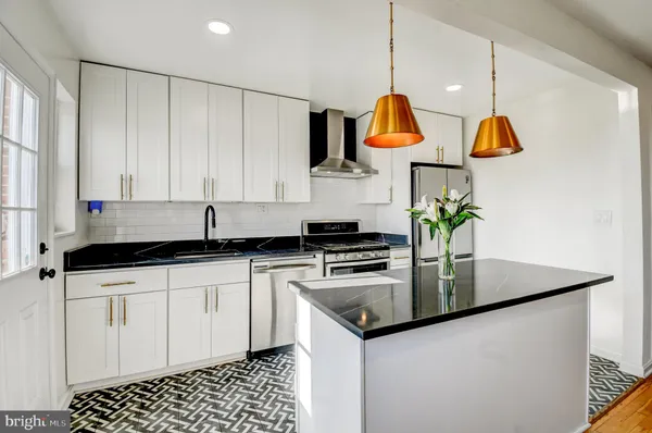a kitchen with stainless steel appliances granite countertop a sink a stove and a microwave