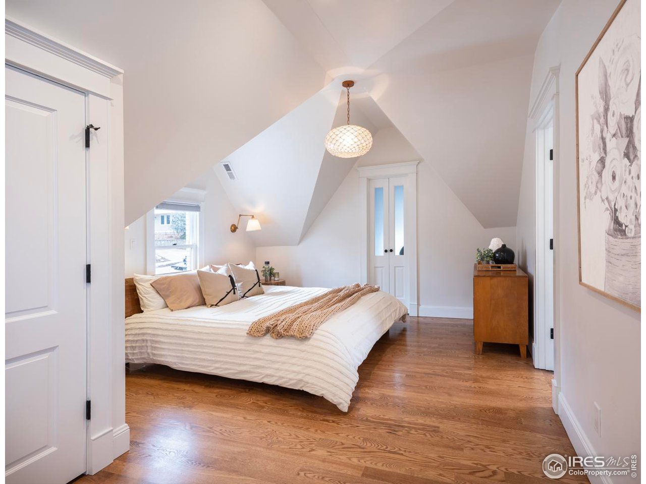 2303 Bluff Street Boulder, CO 80304 - Photo 20 of 40 a bedroom with a bed and a chandelier